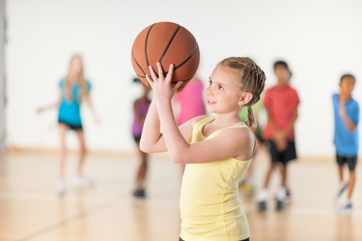 Kind hat keine Freunde: Mädchen spielt Basketball im Sportunterricht