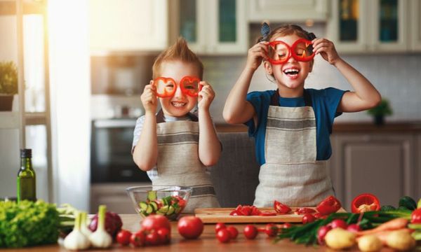 Übergewicht bei Kindern durch Corona: zwei Kinder beim Gemüse schneiden in der Küche