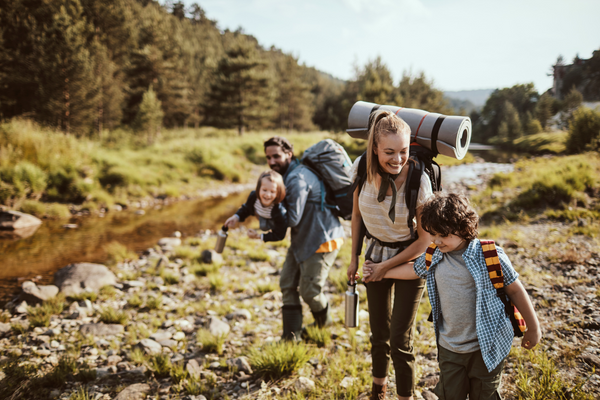 Ausflugsziele Deutschland: Eltern und Kinder wandern mit Rucksaecken durch die Natur