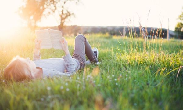 Draußen lernen: Mädchen liest Buch auf der Wiese