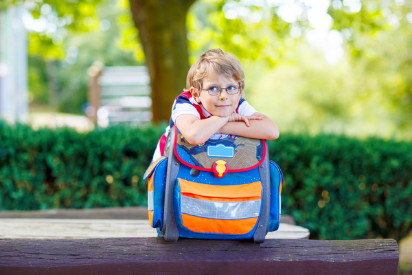 Kinder-Schulranzen: Junge draußen mit Schulranzen