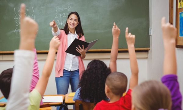 Lernerfolg: Lehrerin in vollem Klassenzimmer mit motivierten Schuelern