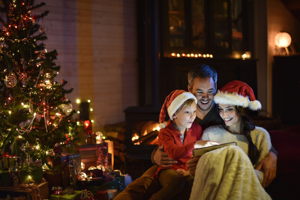 Weihnachtsstimmung_Familie sitzt am Weihnachtsbaum