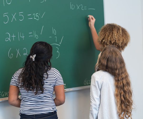 Hochbegabte Kinder: Kinder loesen Matheaufgaben an Tafel