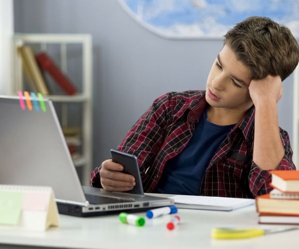 Prokrastination ueberwinden: Junge am Handy beim Lernen